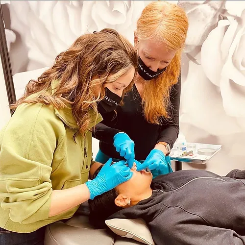 An instructor guiding a trainee injecting a live model during hands-on injection training