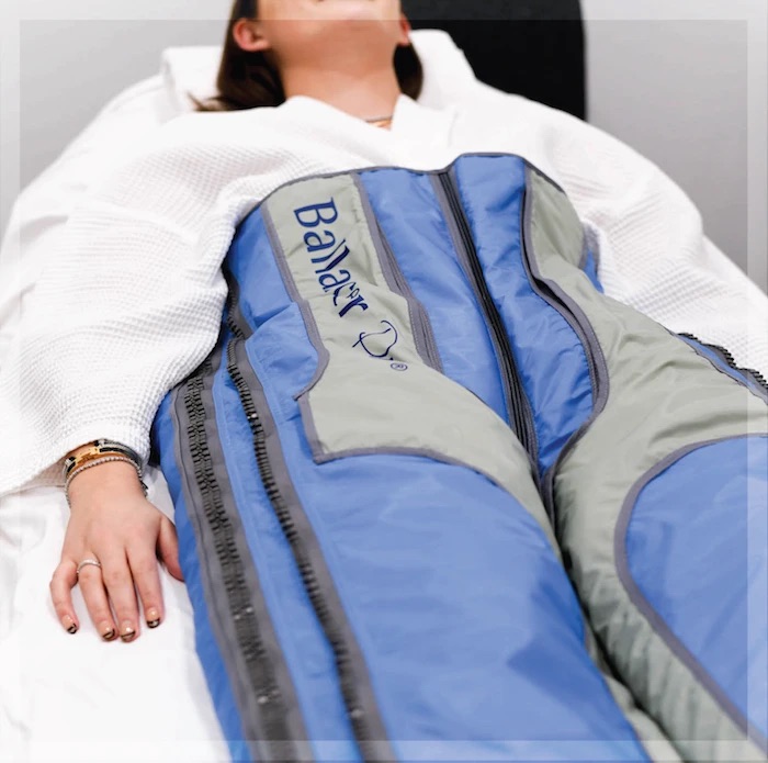 A client lying in a Ballancer Pro compression suit during lymphatic drainage