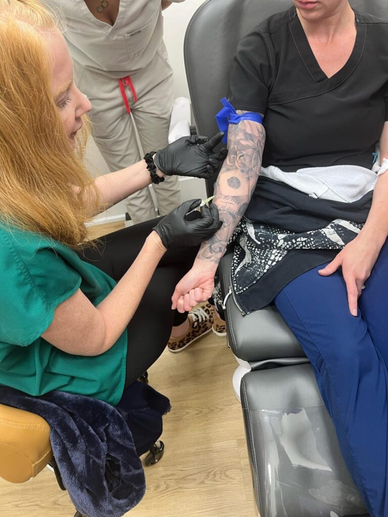 Trainees practising IV placement on each other during an IV nutrition therapy workshop